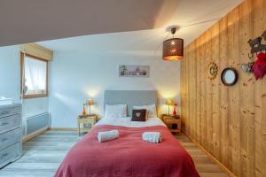 Domancy的住宿－Le Repaire de l'Ours - 10min des pistes，一间卧室配有一张带红色毯子的大床