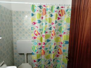 bagno con tenda per la doccia e servizi igienici di Nikos Rooms a Loutra Edipsou Altre 74 foto