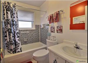 La salle de bains est pourvue de toilettes et d'un rideau de douche. dans l'établissement Cozy House B&B, à Niagara Falls