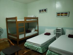 a room with two bunk beds and a chair at Old Orangewood Bed & Breakfast in Baguio