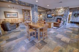 a living room with a wooden table and a fireplace at Black Bear 8035 in Keystone