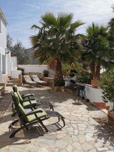 a group of lawn chairs sitting on a patio at One Life Málaga Retreat in Periana