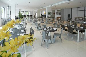 a dining room with tables and chairs and yellow flowers at Cathayana Hotel Kuantan in Kuantan