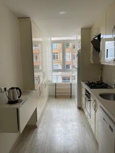 a kitchen with white counters and a large window at Flance hotel furnished home with all amenites in Basaksehir