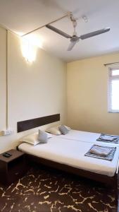 a bedroom with a large white bed with a ceiling at Hotel Paulino in Madgaon