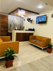 a living room with two couches and a tv at HOTEL TOUCHWOOD in Visakhapatnam