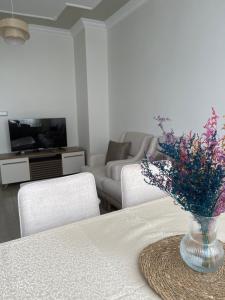 a vase with flowers on a table in a living room at Flance hotel furnished home with all amenites in Basaksehir