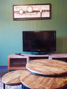 a living room with two wooden tables and a flat screen tv at L'Oullinois Spacieux et Calme T2 15min sud de Lyon proche Métro et Gare Confluence Aquarium Gerland in Oullins