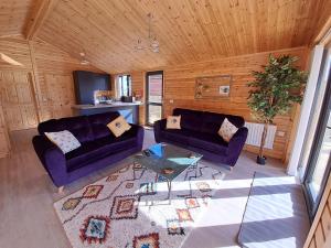 uma sala de estar com dois sofás e uma mesa em Nature's Nook - Norfolk Broads em Brundall