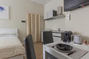 a room with a bed and a kitchen with a table at Center Rooms in Piacenza