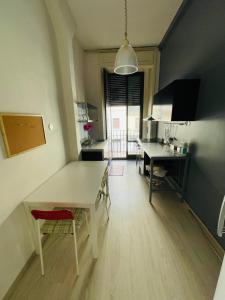 a living room with a table and a kitchen at Deodato Guest House in Catania