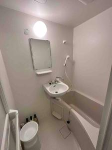 ein Badezimmer mit einem Waschbecken, einem WC und einem Spiegel in der Unterkunft 004.Kumamon Room in Hanabatachō