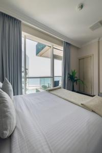 a bedroom with a large white bed with a large window at Al Bateen Residences, Jumeirah Beach Residence - Mint Stay in Dubai