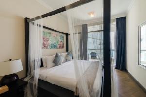 a bedroom with a bed with mosquito netting at Al Bateen Residences, Jumeirah Beach Residence - Mint Stay in Dubai