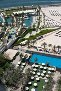 an aerial view of a resort pool with umbrellas and a beach at Al Bateen Residences, Jumeirah Beach Residence - Mint Stay in Dubai