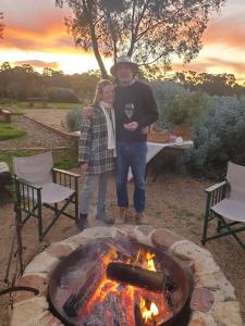 a man and woman standing in front of a fire pit at Byronsvale Vineyard and Accommodation in Bendigo