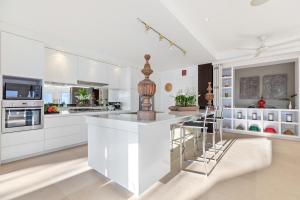 a kitchen with white cabinets and a large island at Panorama Summit - Private Pool with Sunset View in Plai Laem