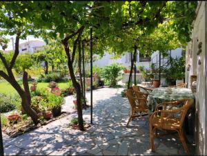 a patio with a table and chairs under a tree at Nicola's House in Myrina
