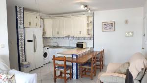 una pequeña cocina con mesa y nevera en Don Paco - Front Line Of The Beach Apartment en Roquetas de Mar