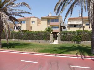 a house on the side of a road with palm trees at Don Paco - Front Line Of The Beach Apartment in Roquetas de Mar