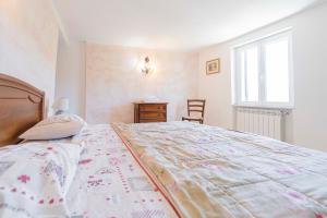 a bedroom with a large bed and a window at CASA VACANZA IL PORTICO in Moneglia