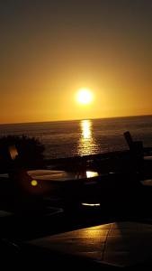 a sunset on the ocean with the sun setting over the ocean at Mobil'home Les Pommes de Pin aux Mathes La Palmyre terrain privé in Les Mathes