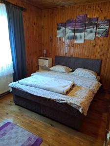 um quarto com uma cama grande numa parede de madeira em Smeštaj u Novoj Varoši, Zlatar em Nova Varos