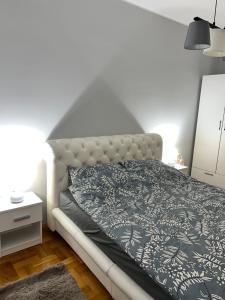 um quarto com uma cama com um cobertor preto e branco em Fairy tale apartment em Dušanovac (historical)