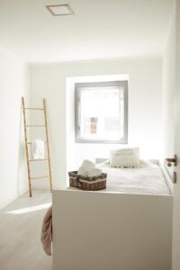 Habitación blanca con cama y ventana en A Casa da Avó Cuca en Amiães de Baixo