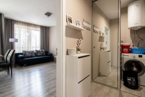 un soggiorno con lavatrice e specchio di Cozy flats nearby center free park area a Varna