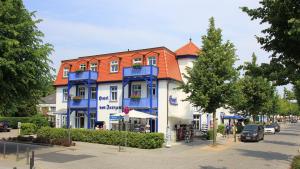 a blue and white building with an orange roof at Hotel von Jutrzenka in Kühlungsborn