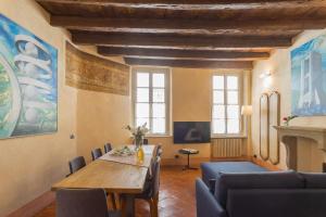un soggiorno con tavolo in legno e sedie blu di Antiche Mura Como by Rent All Como a Como