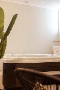 a bath tub sitting in a room with a plant at A Casa da Avó Cuca in Amiães de Baixo