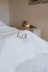 a white blanket on a bed with the word flu on it at A Casa da Avó Cuca in Amiães de Baixo