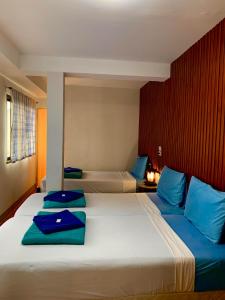 a hotel room with two beds with blue pillows at Ban Wiang Guest House in Chiang Mai