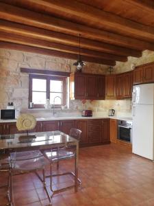 a kitchen with a table and a white refrigerator at Villa Karissa - Zante in Vasilikos