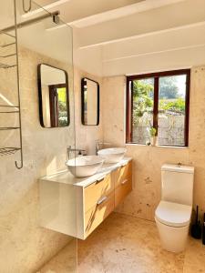 a bathroom with two sinks and a toilet at Petit Casa Central Stellenbosch in Stellenbosch +10 photos