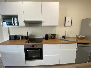 a kitchen with white cabinets and a sink at Duplex-By Aurelle 1-WIFI-10 mn Strasbourg Centre-Proche Parlement Européen in Schiltigheim