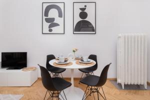 a dining room with a white table and black chairs at City Centre & Cosy Apartment by Renters in Gdańsk