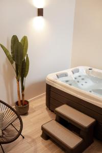 a bath tub in a room with a potted plant at A Casa da Avó Cuca in Amiães de Baixo