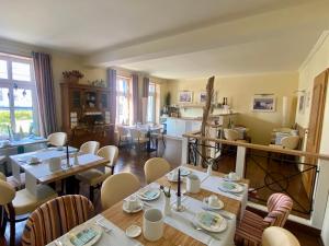 a dining room with tables and chairs and a kitchen at Hotel von Jutrzenka in Kühlungsborn