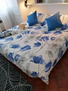 uma cama com lençóis e almofadas azuis e brancos em Mare Verde em San Bartolomeo al Mare