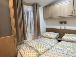 twee bedden in een kleine kamer met een raam bij Charming 5-Beds Caravan in beautiful Seton Sands in Port Seton