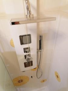 uma casa de banho com um chuveiro e um telefone na parede em Mare Verde em San Bartolomeo al Mare