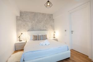 een witte slaapkamer met een groot bed met 2 kussens bij City Center Accommodation - 404 in Reşiţa