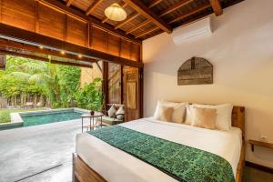 a bedroom with a bed and a swimming pool at Rimba Villas Gili Air in Gili Islands