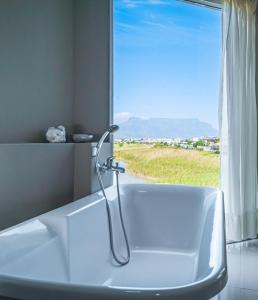 a bathroom with a bath tub with a window at Gaia Hydro-Spa and Guest House in Cape Town