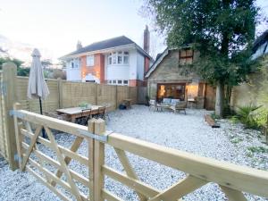 a backyard with a wooden fence and a wooden table at The Coach House - Bournemouth in Bournemouth