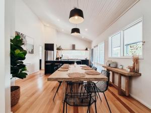 a kitchen with a large wooden table with chairs at Sea Haven, A Rye Coastal Retreat! in Rye