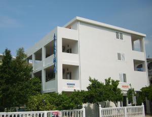 a white building with trees in front of it at Lyon Apartments in Budva